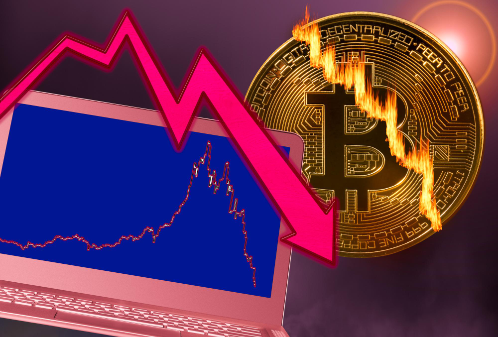 Bitcoin coin cracked in market crash with laptop graph